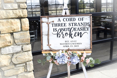 White unity ceremony sign with custom names on an easel for wedding
